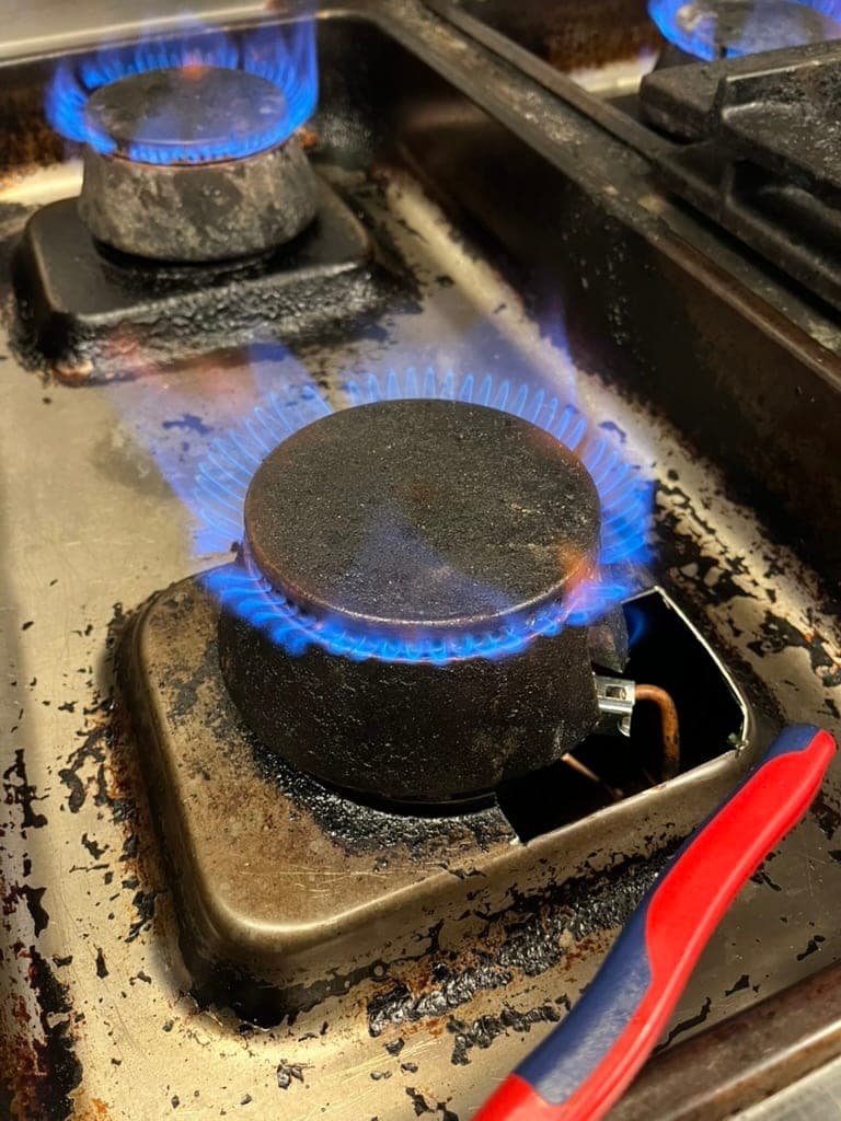 Gasbrännare med jämn blå låga efter service i ett restaurangkök
