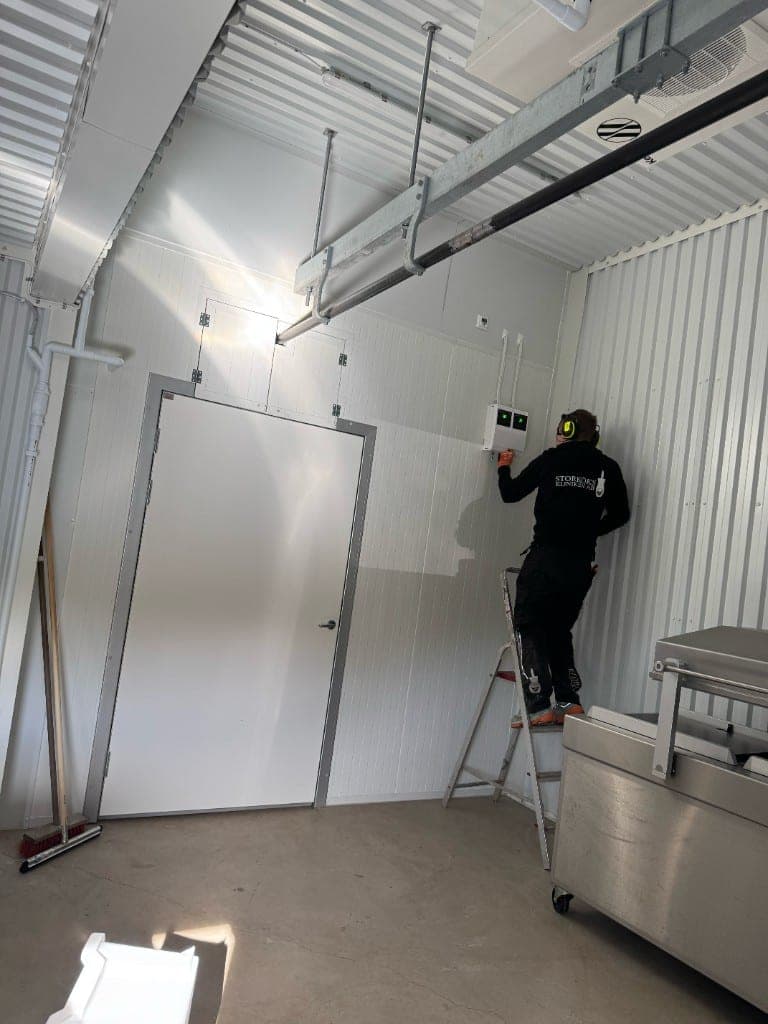 Tekniker ansluter styrskåp vid en kylinstallation i ett slakteri